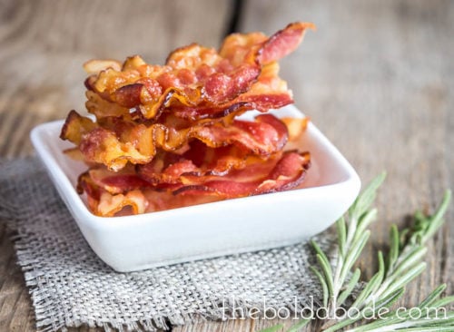 crispy bacon in a bowl with some rosemary