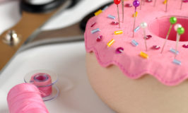 pin cushion, pink thread and scissors