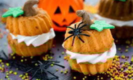 mini pumpkin cakes decorated with plastic spiders