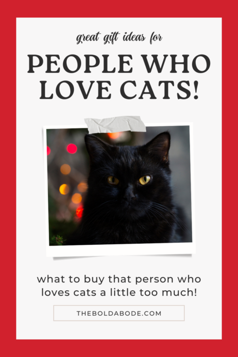 pinterest pin with a black cat sitting by a christmas tree