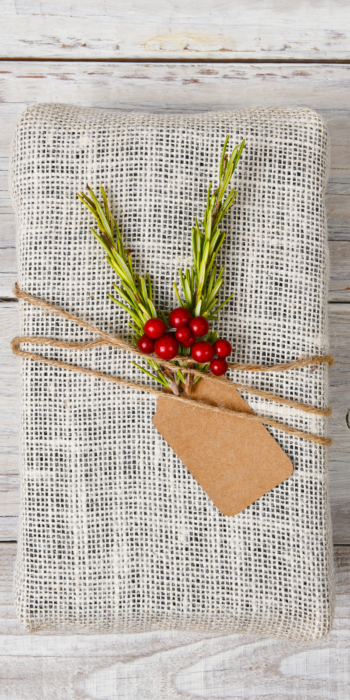 christmas gift wrapped in burlap and rosemary with twine